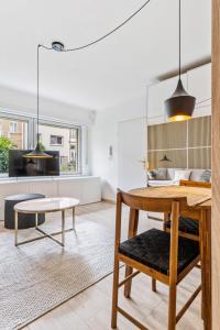 cocina y sala de estar con mesa y banco en Chic Limpertsberg Studio with Free Parking & Wi-Fi, en Luxemburgo