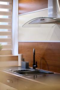 a kitchen with a sink and a stove at Trón Apartman 2 in Siklós +36 photos