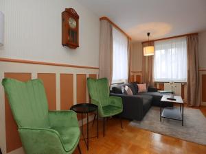 Una sala de estar con un sofá y sillas y un reloj. en Mountain Biker s Farmstay, en Villingen-Schwenningen