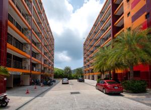 a red car parked in a parking lot next to buildings at 1bdr Spacious Studio near NaiHarn Beach by Capital Pro in Phuket Town