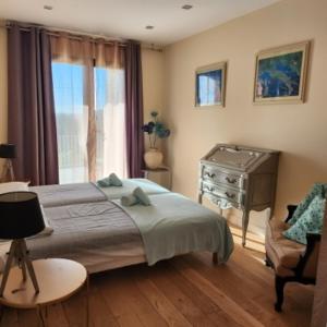 ポルト・ヴェッキオにあるChambre Mustang avec piscine Villa CasaEvaのベッドと机と椅子のある寝室