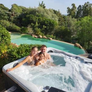 ポルト・ヴェッキオにあるChambre Mustang avec piscine Villa CasaEvaのジャグジー浴槽に入る人々
