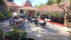 eine Gruppe von Stühlen und Tischen im Innenhof in der Unterkunft Kampung Baron Cottage in Yogyakarta