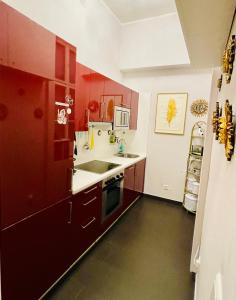 a kitchen with red cabinets and a sink at Feel at home - Self Check In in Vienna +66 photos