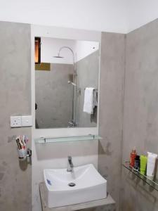 a bathroom with a white sink and a mirror at Kaaya Breeze in Tittawelgolla