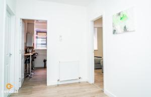 a hallway with white walls and a white radiator at CENTRAL SERVICED APARTMENTS - 2 Bedroom - Walk Away from City Centre & Universities - Sleeps 4 - 3 x Double Beds - Smart TVs in All Rooms - Short Term Stays Welcome - Walk away from Train & Bus Station - Preferred Location for Short Stay in Dundee in Dundee +25 photos