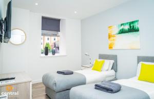 a living room with two beds and a couch at CENTRAL SERVICED APARTMENTS - 2 Bedroom - Walk Away from City Centre & Universities - Sleeps 4 - 3 x Double Beds - Smart TVs in All Rooms - Short Term Stays Welcome - Walk away from Train & Bus Station - Preferred Location for Short Stay in Dundee in Dundee