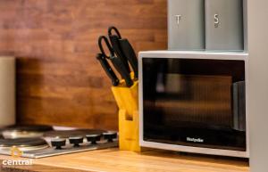 a knife block filled with knives next to a microwave at CENTRAL SERVICED APARTMENTS - 2 Bedroom - Walk Away from City Centre & Universities - Sleeps 4 - 3 x Double Beds - Smart TVs in All Rooms - Short Term Stays Welcome - Walk away from Train & Bus Station - Preferred Location for Short Stay in Dundee in Dundee