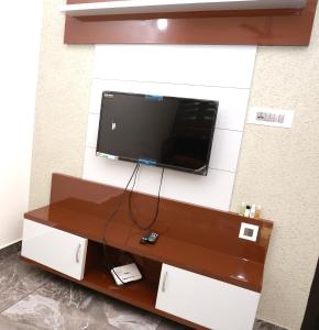 Un televisor de pantalla plana colgado en una pared en ECOSTAY inn, en Sultan Bathery