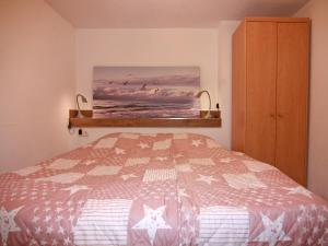 a bedroom with a bed and a painting on the wall at Wohnung in Boltenhagen am Ostseestrand in Boltenhagen