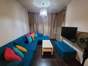 a living room with a blue couch and a tv at Healing & Relaxation Studio in Porto Sharm in Sharm El Sheikh