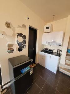 a kitchen with a black refrigerator and white cabinets at Healing & Relaxation Studio in Porto Sharm in Sharm El Sheikh