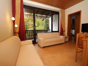 a living room with a couch and a large window at Ferienwohnung im Haus Schiefertal, Wieda in Wieda