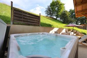 a hot tub in a backyard with a table and chairs at Les flocons in Crest-Voland