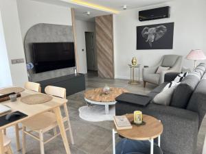 a living room with a couch and a tv and tables at Leos Apartments Apart2 in Side