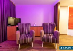 two chairs in a room with purple walls at Motel Portofino in Matosinhos