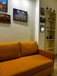 eine orangefarbene Couch im Wohnzimmer in der Unterkunft Cavour Housing in Bari + 2 Fotos