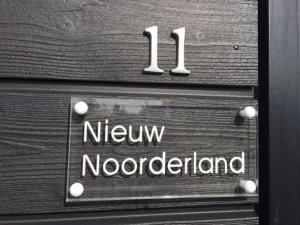 a sign that says new noordeland on a wooden door at Nieuw Noorderland - Ecohuisjes Terschelling in Midsland