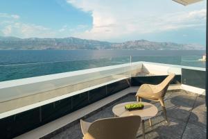a balcony with a table and chairs and the ocean at Grand Hotel View in Postira