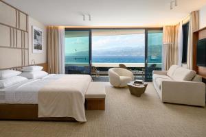 a bedroom with a large bed and a view of the ocean at Grand Hotel View in Postira