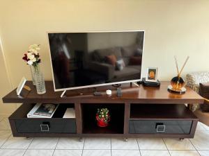 a tv sitting on top of a wooden entertainment center at Cantinho da Carol - Pituba - Localização Perfeita! in Salvador