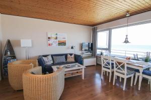 a living room with a couch and a table and chairs at Monopol 306 in Wangerooge