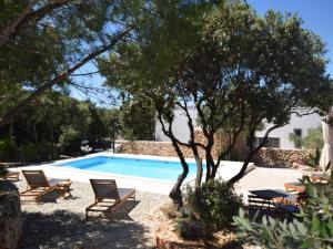 a swimming pool with chairs and trees in a yard at Tranquil Poolside Getaway in Mandre