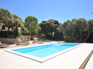 a swimming pool in a backyard with chairs and trees at Tranquil Poolside Getaway in Mandre