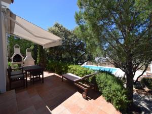 a patio with a table and a white umbrella at Tranquil Poolside Getaway in Mandre