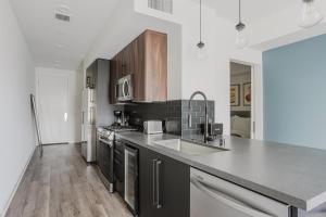 a kitchen with a sink and a refrigerator at Blueground Long Beach pool courtyard nr shops LAX-1259 in Los Angeles