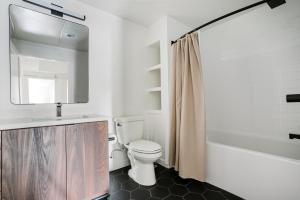 a bathroom with a toilet and a sink and a tub at Blueground Long Beach pool courtyard nr shops LAX-1259 in Los Angeles +24 photos