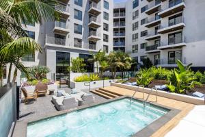 an apartment patio with a swimming pool and a building at Blueground Long Beach pool gym near bars LAX-1260 in Los Angeles