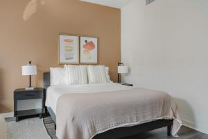 a bedroom with a large white bed with two lamps at Blueground Long Beach pool gym near bars LAX-1260 in Los Angeles