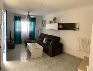 salon z brązową kanapą i stołem w obiekcie Apartamento Tanzanita w mieście Costa Calma