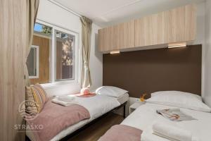 a bedroom with two beds and a window at Mobile Home in Pag near Pebble Beach in Novalja +33 photos