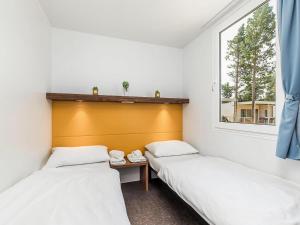 two beds in a room with a window at Mobile Home by Novalja Beach with Pools in Novalja +31 photos