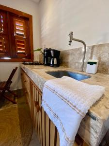 a kitchen with a sink with a towel on the counter at Casa Pitanga Flat in Jericoacoara