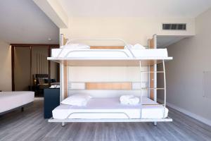 two bunk beds in a room with wood floors at TRYP by Wyndham Lisboa Caparica Mar in Costa da Caparica