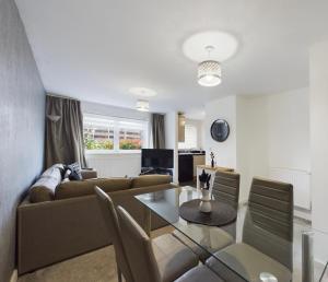 a living room with a couch and a table at Modern 2 bed city apartment with private parking in Swansea