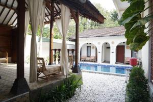 a pavilion with a chair and a swimming pool at Villa de Tristan Yogyakarta in Mutihan