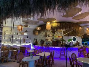 a restaurant with tables and chairs and a bar at Manawari Beach Resort in Caliclic