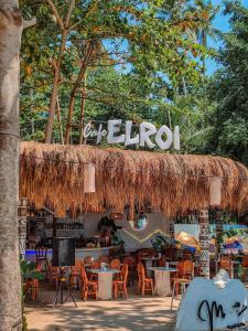 a restaurant with a straw roof and tables and chairs at Manawari Beach Resort in Caliclic