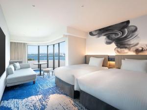 a hotel room with two beds and a chair at Grand Mercure Awaji Island Resort & Spa in Minamiawaji