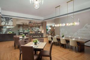 a dining room with tables and chairs and a bar at Wyndham Garden Haikou Meilan in Haikou