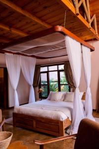 a bedroom with a canopy bed with a window at Ngorongoro Marera Mountain View Lodge in Karatu
