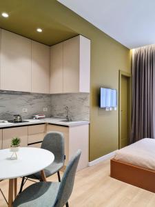 a room with a bed and a table and chairs at Meri Apartment in Tirana