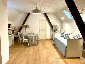 a bedroom with a bed and a table and a kitchen at MAISON privée, La glycine blanche, a 10min de Strasbourg in Schiltigheim
