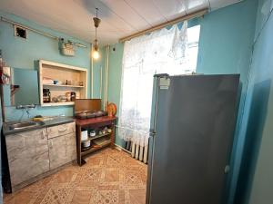 una cucina con pareti blu e frigorifero di Bayil Apart 1R a Baku
