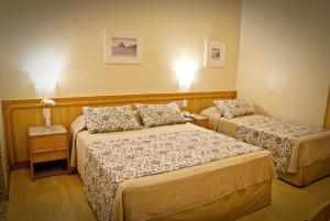 a hotel room with two beds in a room at Hotel Regina Rio de Janeiro in Rio de Janeiro