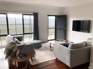 a living room with two couches and a flat screen tv at Golden Valley - Steels Creek in Steels Creek